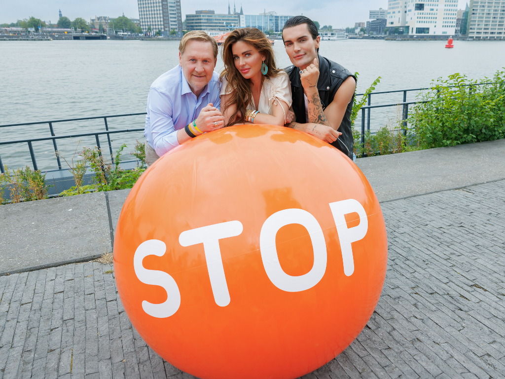 Stoptober ambassadeurs poseren op de oranje Stoptober-al: Oos Kesbeke, Sylvia Geersen en Koen Pieter van Dijk